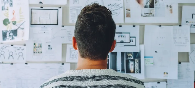person looking at a wall of papers