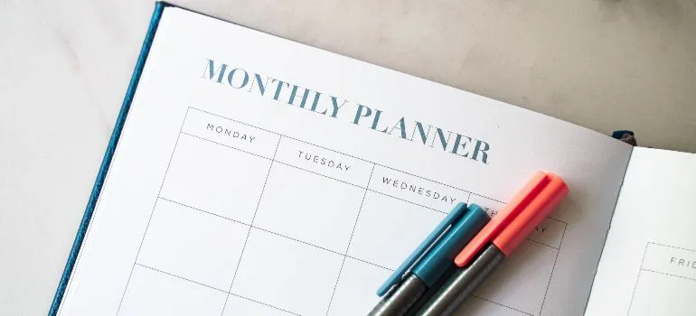 a monthly planner with two pens on it