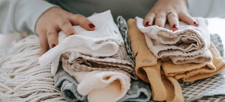 Woman folding clothes before storing winter wardrobe