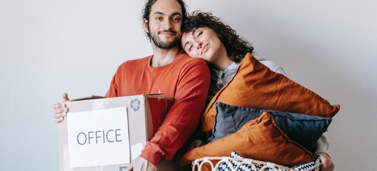 a couple smiling and holing items