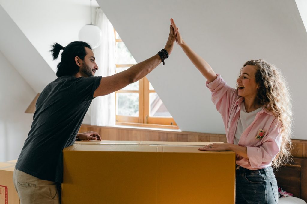 couple with moving boxes excited about moving from Meridian to Fort Collins