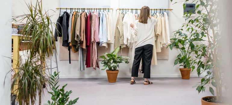 woman going through clothes on arack