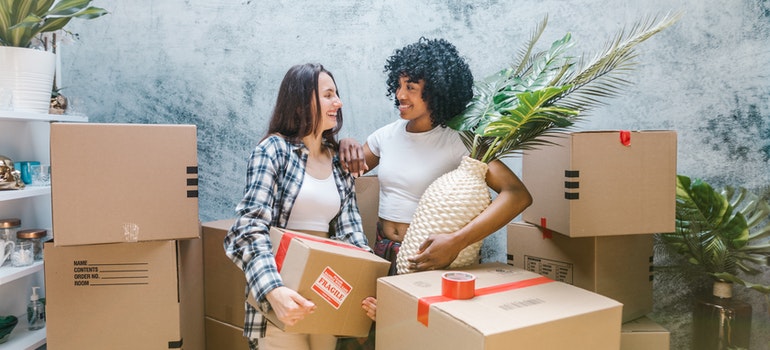 two women packing and talking how retail stores benefit from self-storage