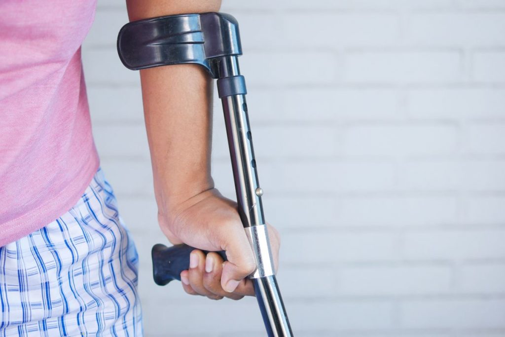 person walking with the help of a crutch