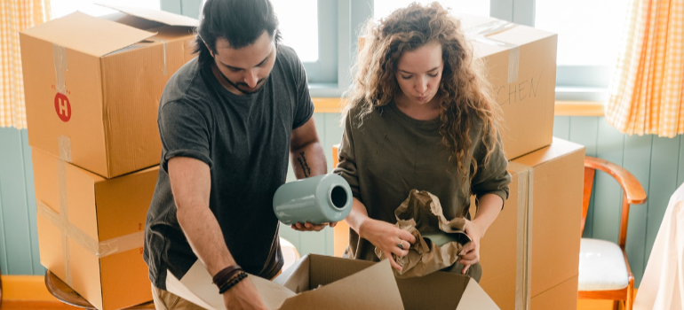 two people packing items for moving