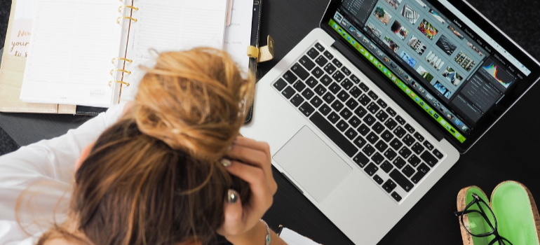 a woman reading on a lap top about common mistakes when hiring moving companies