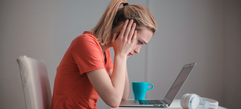a worried woman reading on a laptop