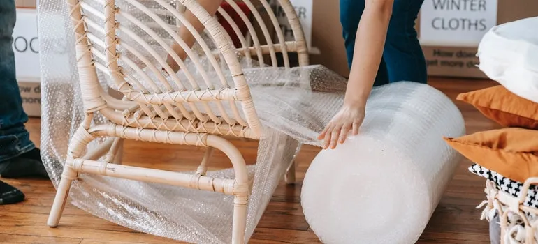 People wrapping furniture and learning how to move in bad weather 
