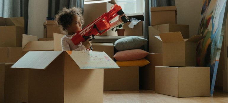 A child with a toy in a moving box