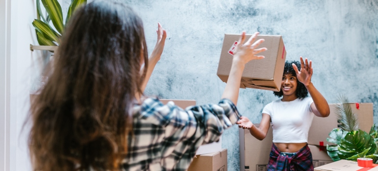 two girls discussing hiring local movers vs moving by yourself