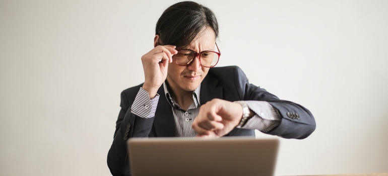 man nervously checking time on his watch