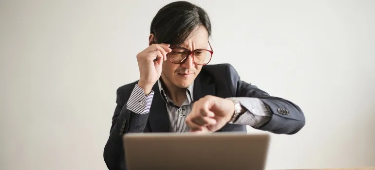 man nervously checking time on his watch