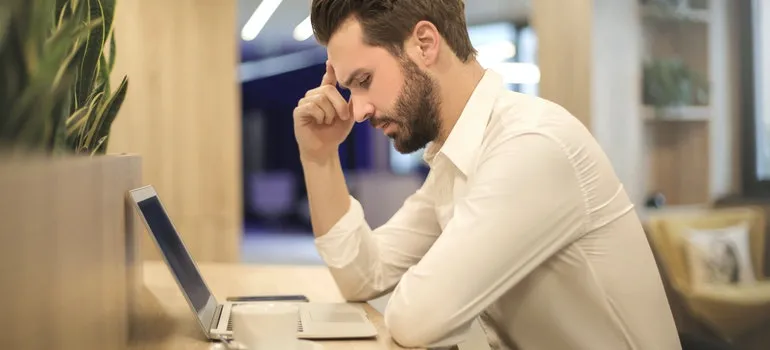 a man reading on a laptop about the difference between Self storage vs commercial warehouse