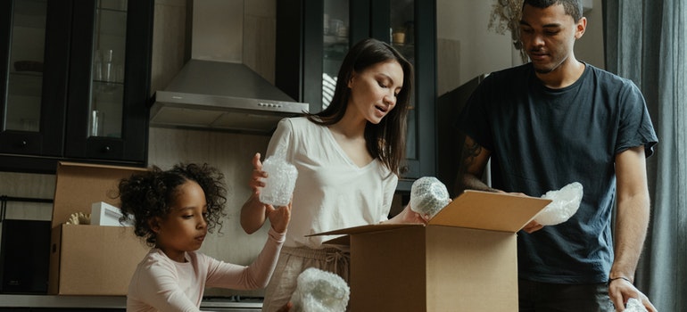 a family of three unpacking a box