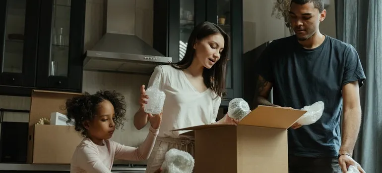 a family of three unpacking a box