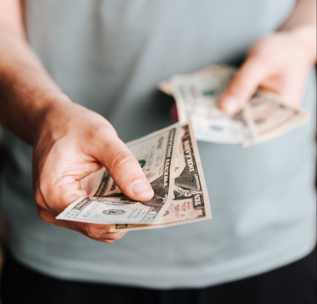 man handing over dollar bills