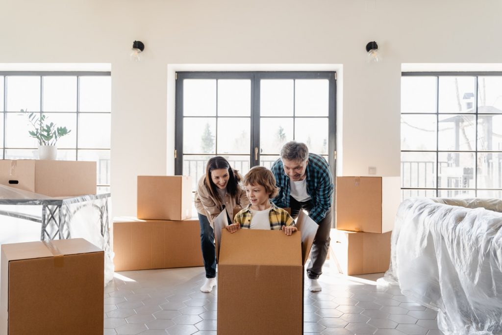 a family of three among moving boxes