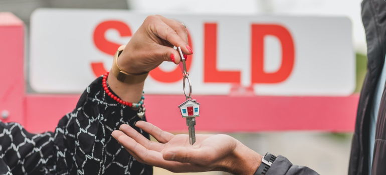 a person holding the keys of home as a part of cost of living in Meridian ID guide