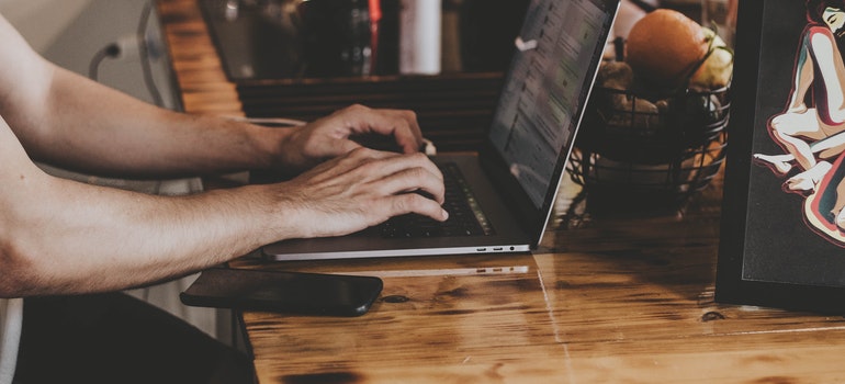person on lap top researching storage companies and benefits of renting storage in Boise