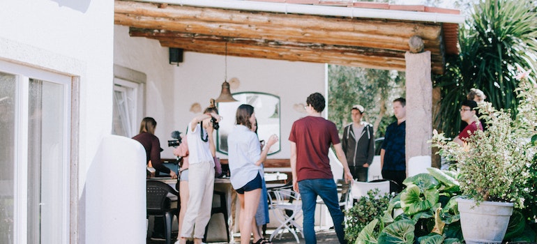friends on a porch making barbique after moving out of the city