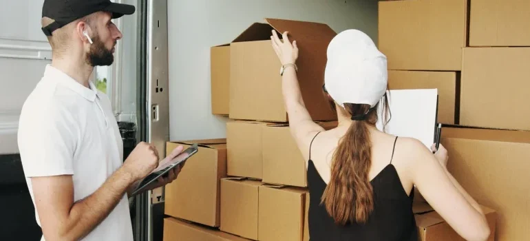 Two movers checking the moving boxes in a truck