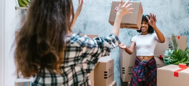 Two women throwing boxes at each other
