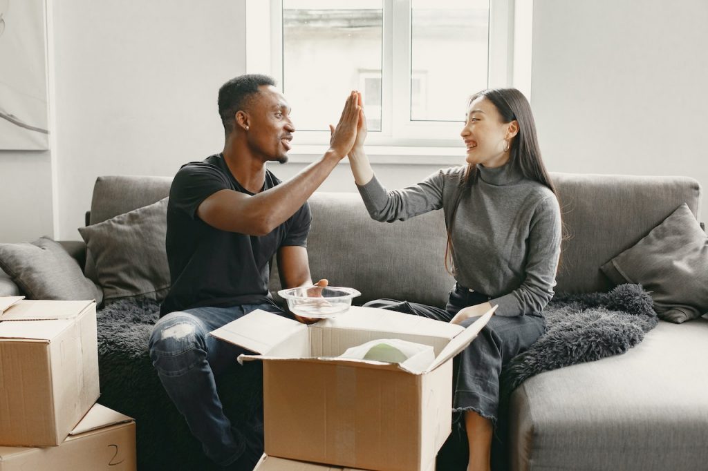 couple on a couch with moving boxes