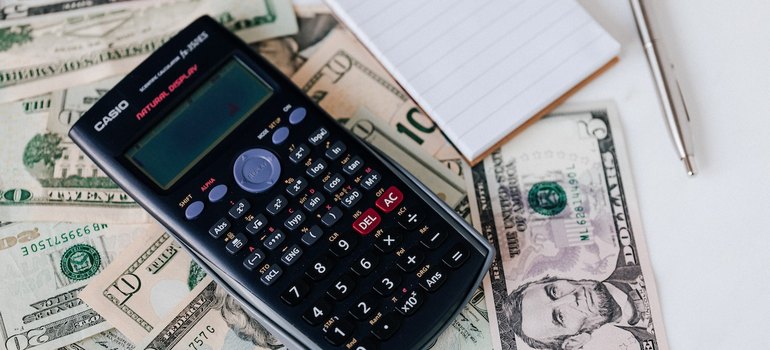 dollars calculator notepad and pen on desk