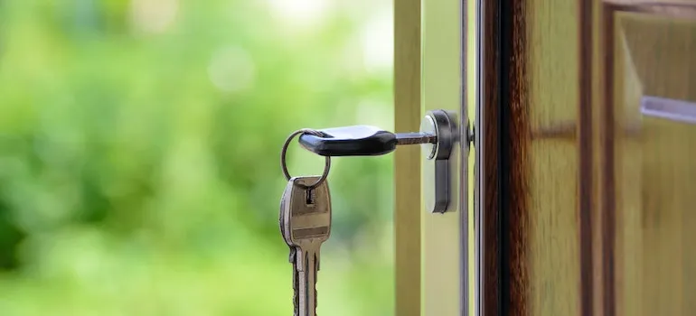 A key is in the keyhole of a door knob.