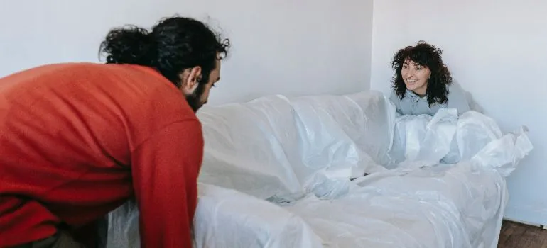 a couple lifting a couch