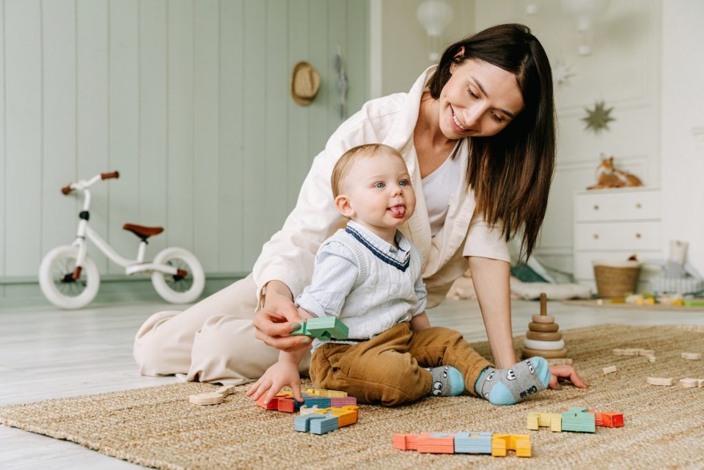 A woman sitting on the floor with a baby