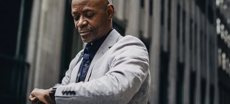 An African-American businessman checking time on wristwatch on street