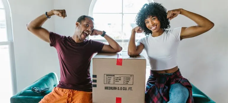 A couple posing with a cardboard box