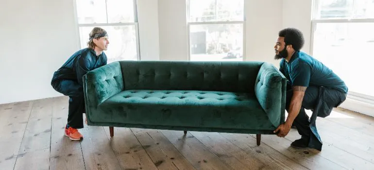 Special movers carrying a green couch