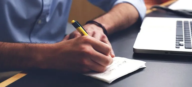 A person is writing down things to remember when planning a move