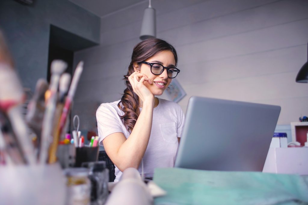 a woman painter looking at her laptop