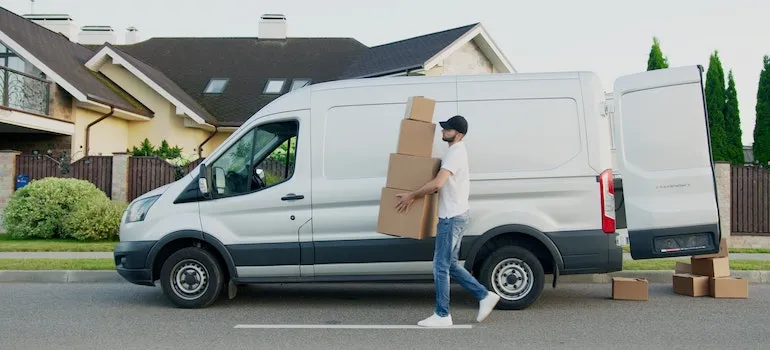 mover with boxes next to a van