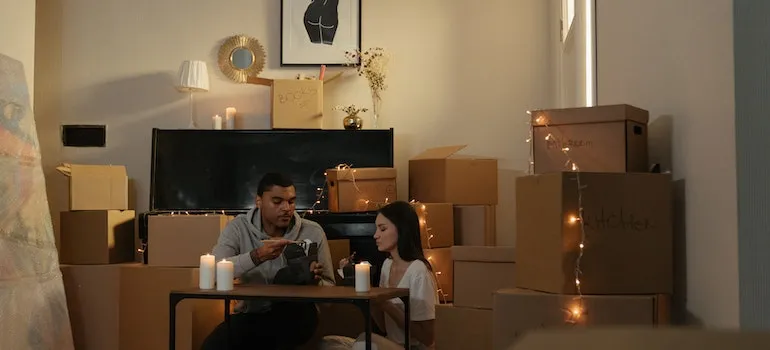A couple moving during the holiday season is sitting between moving boxes and holiday decorations