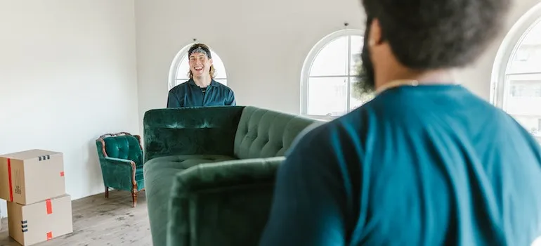 Two movers handling heavy furniture represent how movers make moving interstate simple