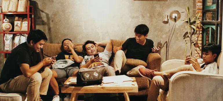 friends sitting in a living room smiling as one of the reasons families decide to move