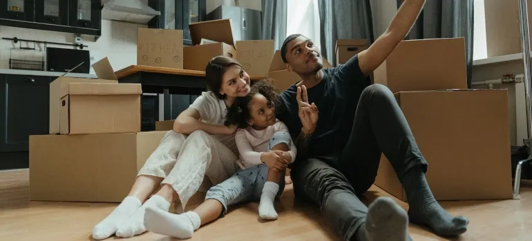 a family taking a picture in front of moving boxes
