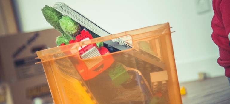 An example of cardboard vs plastic moving boxes used for storing toys