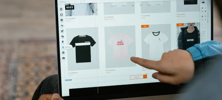 a person pointing at a t-shirt on an online product page