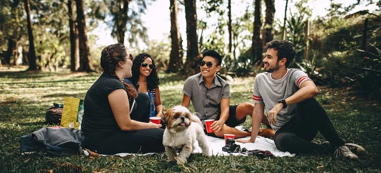 group of friends having a picnic in a park and laughing