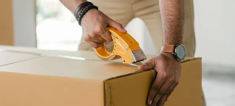 a man taping a box during packing and shipping medical equipment