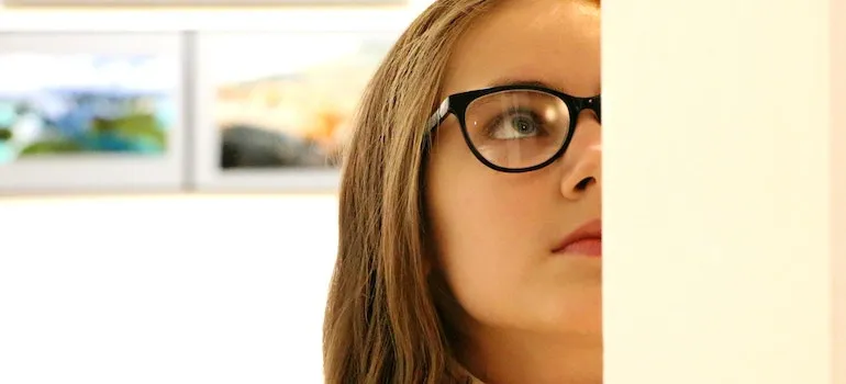A woman with glasses looking at a painting in one of the arts and culture stops to make in Boise