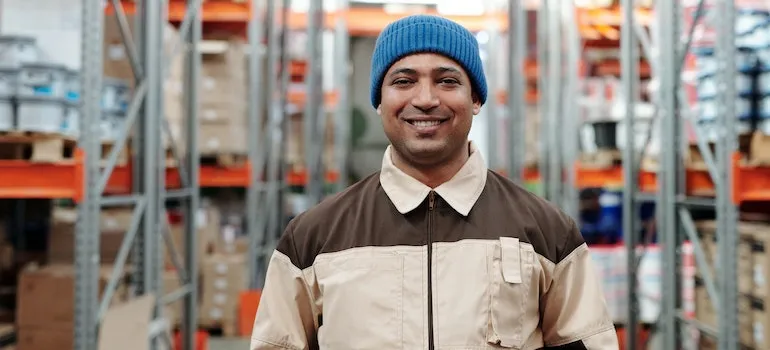 A factory worker smiling because he knows all about industrial storage and its uses
