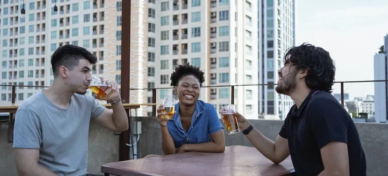 A group of friends drinking beer and laughing about facts about Boise suburbs