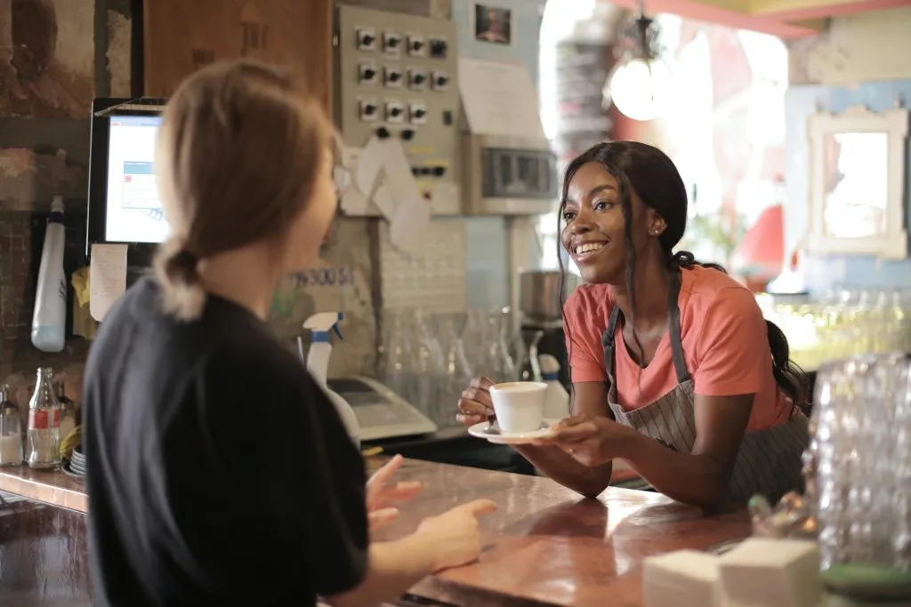 Barista giving coffee to a customer