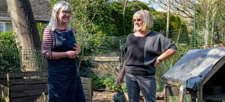 Two women in a garden smiling represnting Treasure Valley's friendly communities